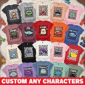 May include: A collection of colorful t-shirts featuring various characters from the movie Cars. Each shirt displays a character's image on a checkered background. The text "CUSTOM ANY CHARACTERS" is at the bottom.