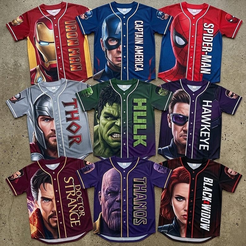 K&ouml;nnte beinhalten: Neun Baseball-Trikots mit Marvel-Superhelden. Die Trikots sind rot, blau, grau, gr&uuml;n, lila und schwarz, mit Charakterbildern und Namen wie Iron Man, Captain America, Spider-Man, Thor, Hulk, Hawkeye, Doctor Strange, Thanos und Black Widow.
