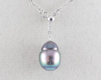 May include: A silver necklace with a single, iridescent pearl pendant. The pearl has a teardrop shape with a dark gray top and a shimmering, multi-colored body. The chain is delicate and hangs against a neutral background.