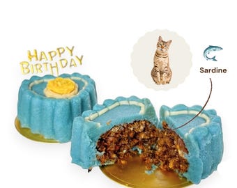 May include: Two blue round cakes on gold bases. One cake is whole with a yellow flower on top and a gold Happy Birthday topper. The other cake is cut in half, revealing a dark brown textured interior. A cat image and a sardine icon with the text Sardine.