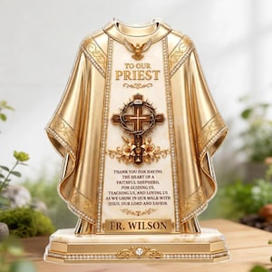 Może przedstawiać: Złoto-kremowa ozdobna tabliczka w kształcie szaty kapłańskiej. Zawiera centralny krzyż, gołębicę oraz tekst: TO OUR PRIEST, THANK YOU FOR HAVING THE HEART OF A FAITHFUL SHEPHERD, FOR GUIDING US, AND FR. WILSON.