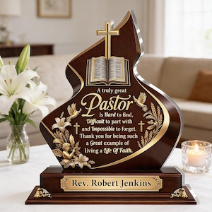 May include: A dark wood plaque with a flame-shaped top featuring a gold cross and open book icon. The text reads: A truly great Pastor is Hard to find, Difficult to part with and Impossible to forget. Thank you for being such a Great example of living a Life Of Faith. A gold nameplate reads: Rev. Robert Jenkins.