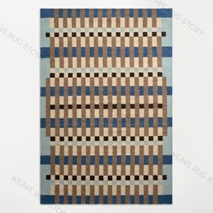 May include: A rectangular area rug featuring a geometric pattern of vertical and horizontal stripes in shades of light blue, medium blue, tan, and black. The design consists of repeating blocks and lines that create a grid-like visual effect.