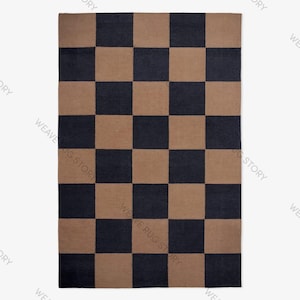 Peut inclure: Un tapis rectangulaire à motif de damier. Le tapis présente des carrés alternés bleu marine foncé et beige. Le tapis est présenté sur un fond blanc. Les mots "WEAVE RUG STORY" sont imprimés sur le tapis.