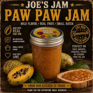 May include: A glass jar of Joe's Jam Paw Paw Jam with a silver lid, surrounded by whole and halved paw paw fruits and a slice of toast topped with jam. The label text reads Joe's Jam Paw Paw Jam, Bold Flavor, Real Fruit, Small Batch, and Homemade.