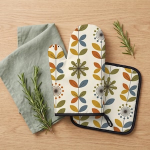 May include: An oven mitt and a square pot holder featuring a cream background with a repeating pattern of vertical stems, stylized flowers, and leaves in shades of olive green, mustard yellow, burnt orange, and slate blue with black outlines.