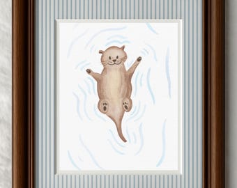 May include: A framed print with a watercolour illustration of an otter floating in water. The otter is depicted in shades of brown, with its arms and legs outstretched. The artwork is set against a light blue and white striped background.