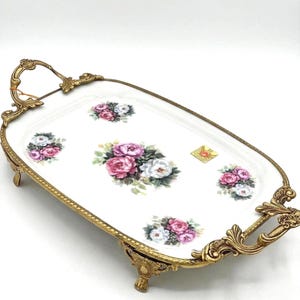 Bandeja de servir de porcelana vintage con diseño floral, rosas rosas, asas de latón ornamentadas y base rectangular.
