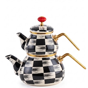 May include: A double-stacked tea kettle featuring a black and white checkered pattern with a brushstroke texture. The kettle has gold-toned metal handles and a small, round, red knob on the lid. The rims are accented with a thin gold-colored trim.