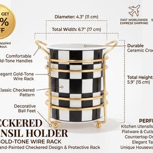 Puede incluir: Un porta utensilios de cerámica con patrón de cuadros en blanco y negro, dentro de una estructura de alambre dorado con asas y pies esféricos. Mide 11 cm de diámetro, 17 cm de ancho total y 15 cm de altura total.