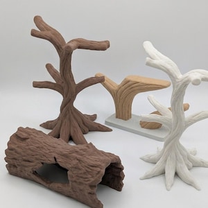 May include: A collection of four decorative items including a dark brown tree-shaped stand, a white tree-shaped stand, a light brown Y-shaped branch on a rectangular base, and a dark brown hollow log-shaped piece with a textured bark surface.
