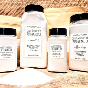 May include: Four white plastic bottles with black lids containing carpet and upholstery deodorizing dusting powder. The bottles are labeled with the brand name "ACellarStudio" and the scent of the powder. The scents are unscented, lavender lemongrass, sweater season, and coffee shop. The bottles are arranged on a wooden surface with a pile of white powder in front of them.