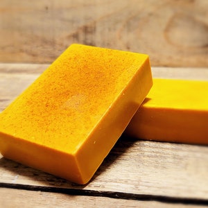 May include: Two bars of bright yellow soap. The soap has a grainy texture.