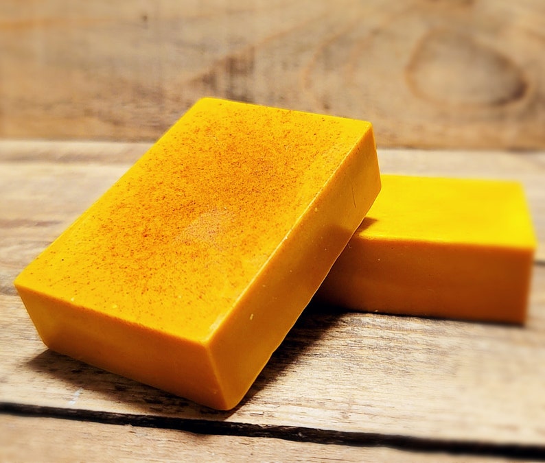 May include: Two bars of bright yellow soap. The soap has a grainy texture.