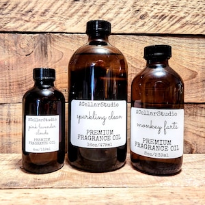 May include: Three amber glass bottles with labels. The bottles contain premium fragrance oil. The labels read "ACellarStudio pink lavender clouds PREMIUM FRAGRANCE OIL 4oz/119ml", "ACellarStudio sparkling clean PREMIUM FRAGRANCE OIL 16oz/479ml", and "ACellarStudio monkey farts PREMIUM FRAGRANCE OIL 8oz/239ml".