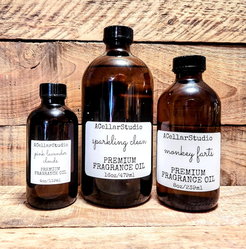 May include: Three amber glass bottles with labels. The bottles contain premium fragrance oil. The labels read "ACellarStudio pink lavender clouds PREMIUM FRAGRANCE OIL 4oz/119ml", "ACellarStudio sparkling clean PREMIUM FRAGRANCE OIL 16oz/479ml", and "ACellarStudio monkey farts PREMIUM FRAGRANCE OIL 8oz/239ml".