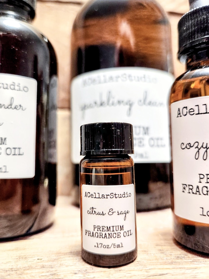 May include: A small brown glass bottle with a black cap and a white label that reads "ACellarStudio citrus & sage PREMIUM FRAGRANCE OIL .17oz/5ml".