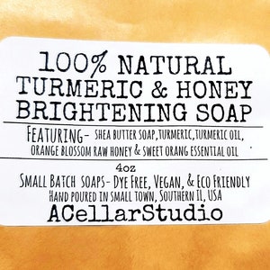 May include: White label with black text that reads "100% Natural Turmeric & Honey Brightening Soap" featuring shea butter soap, turmeric, turmeric oil, orange blossom raw honey & sweet orange essential oil. 4 oz. Small batch soaps - dye free, vegan, & eco friendly. Hand poured in small town, Southern IL, USA. ACellarStudio.