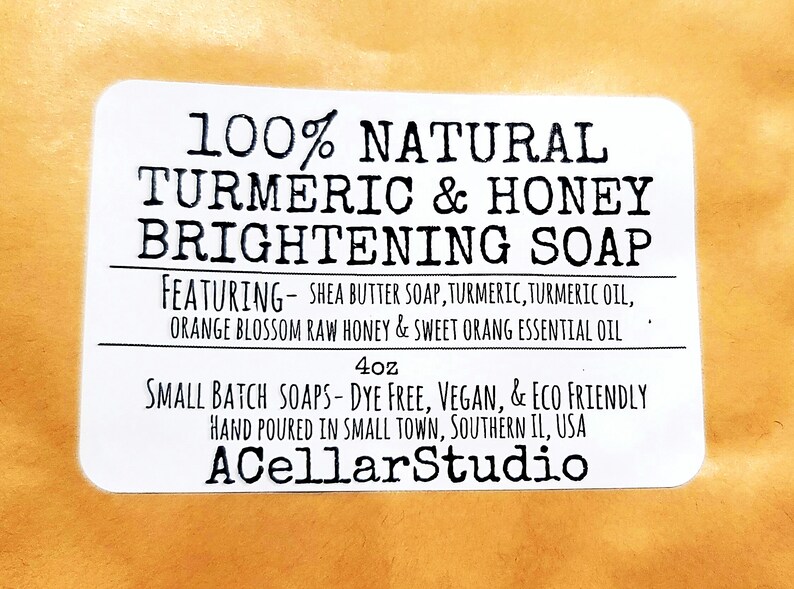 May include: White label with black text that reads "100% Natural Turmeric & Honey Brightening Soap" featuring shea butter soap, turmeric, turmeric oil, orange blossom raw honey & sweet orange essential oil. 4 oz. Small batch soaps - dye free, vegan, & eco friendly. Hand poured in small town, Southern IL, USA. ACellarStudio.