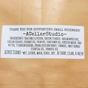 May include: White label with black text that reads "Thank you for supporting small business! -ACellarStudio- Ingredients- Vegetable glycerin, sodium stearate, sodium myristate, sodium cocoate, coconut oil, palm oil, sunflower oil, purified water, shea butter, titanium dioxide, orange blossom honey, turmeric, sweet orange essential oil, turmeric oil Directions-Wet, lather, wash, rinse, dry...be shiny, clean, & fresh!"