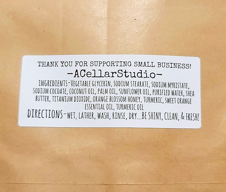 May include: White label with black text that reads "Thank you for supporting small business! -ACellarStudio- Ingredients- Vegetable glycerin, sodium stearate, sodium myristate, sodium cocoate, coconut oil, palm oil, sunflower oil, purified water, shea butter, titanium dioxide, orange blossom honey, turmeric, sweet orange essential oil, turmeric oil Directions-Wet, lather, wash, rinse, dry...be shiny, clean, & fresh!"