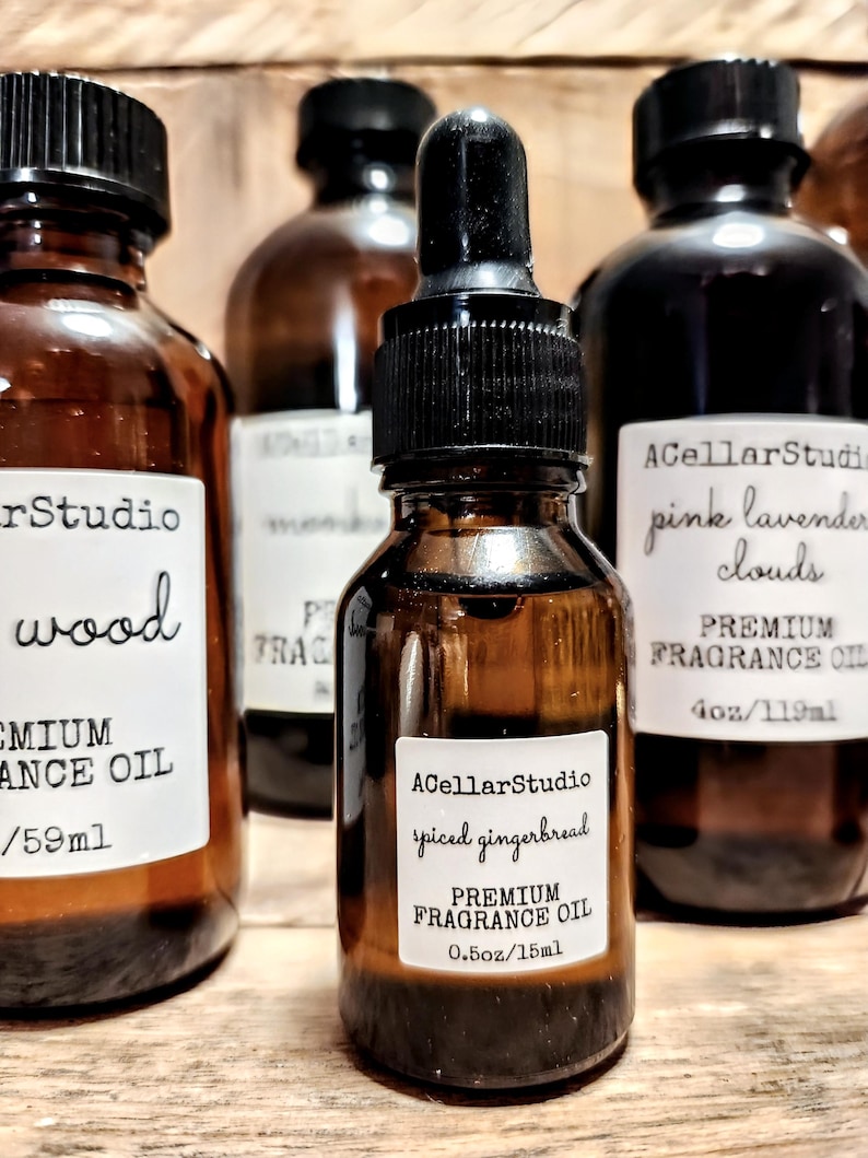 May include: Three amber glass bottles with black lids and labels. The center bottle is a smaller size and contains a premium fragrance oil with a spiced gingerbread scent. The label reads "ACellarStudio spiced gingerbread PREMIUM FRAGRANCE OIL 0.5oz/15ml".