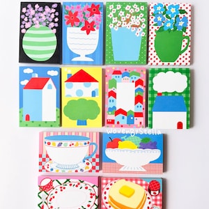 Könnte beinhalten: Eine Sammlung von elf rechteckigen Notizblöcken mit farbenfrohen Illustrationen von Blumenvasen, Häusern und Lebensmitteln wie Teetassen, Obstschalen und Toast mit Butter. Die Designs enthalten Muster wie Punkte, Streifen und Vichy-Karos.