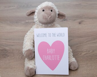 May include: A white plush lamb holding a card that says "Welcome to the world Baby Charlotte" with a pink heart.