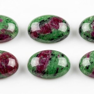 Puede incluir: Seis piedras preciosas cabujón de forma ovalada con una superficie pulida que presenta un patrón moteado de rojo magenta intenso, verde vibrante e inclusiones negras. Cada piedra muestra una parte superior lisa y redondeada.