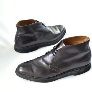May include: A pair of dark brown leather ankle boots with laces. The boots have a rounded toe and a thick sole.