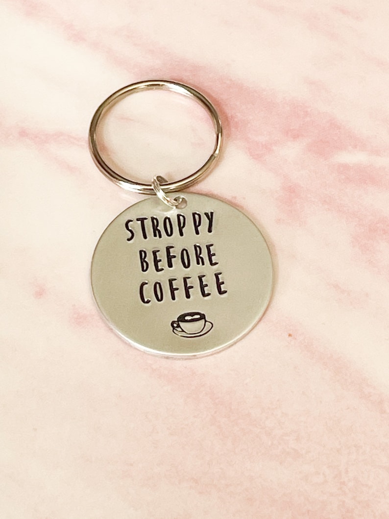 May include: Silver keychain with the text "STROPPY BEFORE COFFEE" and a small coffee cup icon.