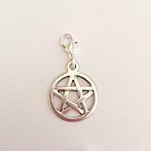 May include: A silver-colored charm with a pentagram design. The charm is circular with a five-pointed star inside a circle. It has a lobster clasp for easy attachment to a bracelet or necklace.