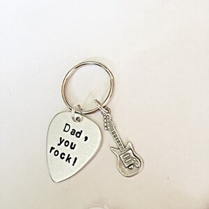 May include: Silver guitar-shaped keychain with a silver pick-shaped charm that reads "Dad, you rock!"