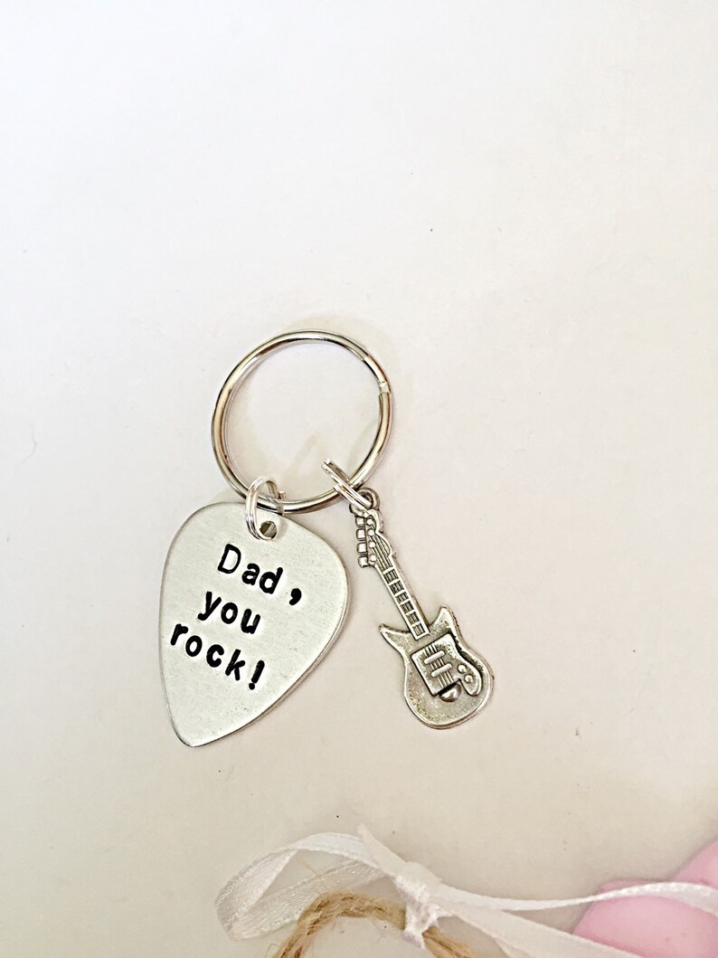 May include: Silver guitar-shaped keychain with a silver pick-shaped charm that reads "Dad, you rock!"