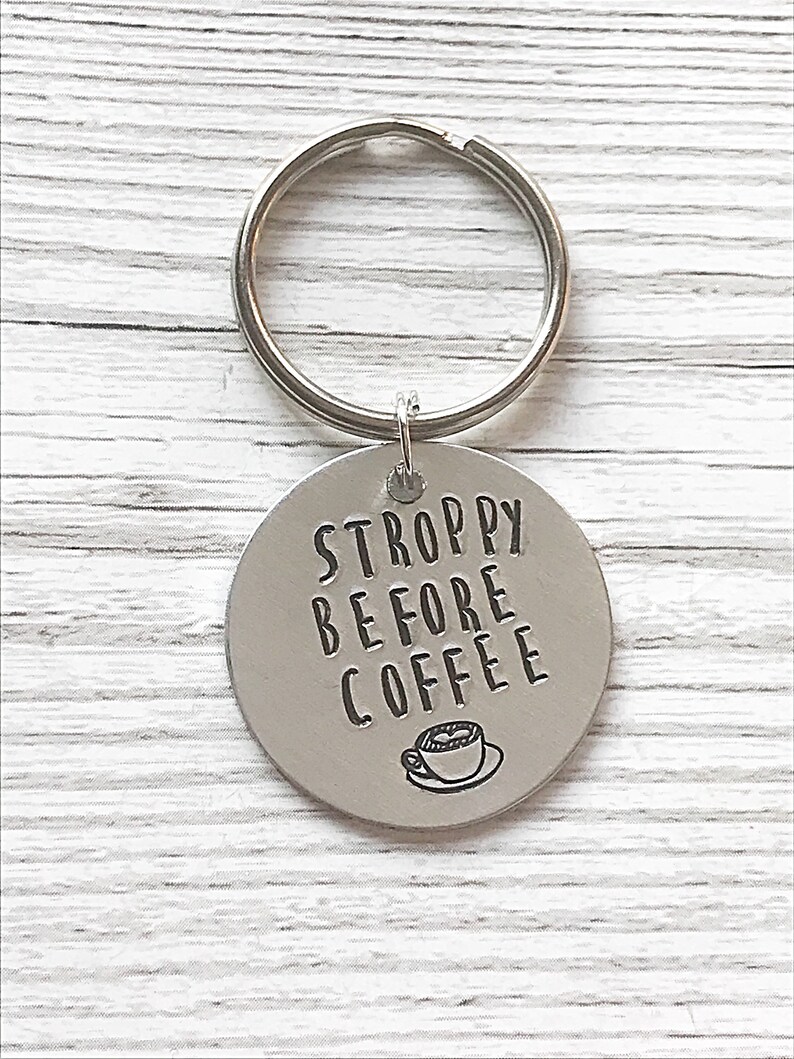 May include: Silver keychain with a round tag that says "STROPPY BEFORE COFFEE" with a small coffee cup icon.