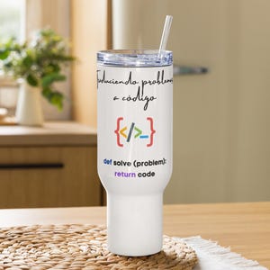 Puede incluir: Vaso térmico blanco con tapa transparente y pajita. El vaso presenta el texto "Traduciendo problemas a código" y un gráfico de corchetes de código. Debajo, el texto "def solve (problem): return code."