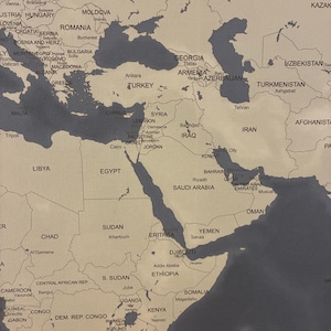 May include: A detailed world map with a neutral color palette, featuring countries and cities labeled in a clear font. The map highlights regions with a dark gray color, contrasting with the beige background. The image is a close-up of the Middle East and surrounding areas.