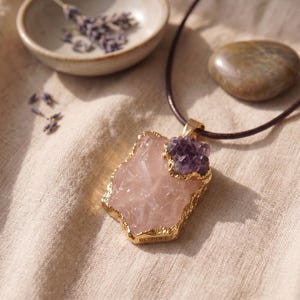 Nahaufnahme der natürlichen Kristallstruktur des Rosenquarzes und der violetten Amethyst Splitter in der goldenen Einfassung