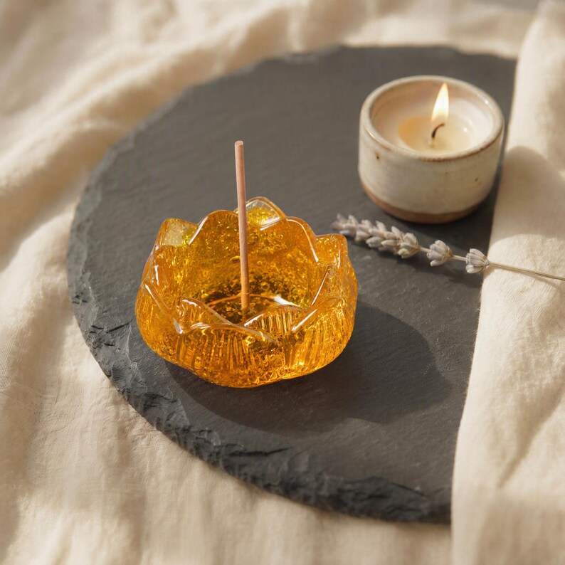 Citrine Lotus Schale als Räucherstäbchenhalter auf einem schwarzen Untergrund