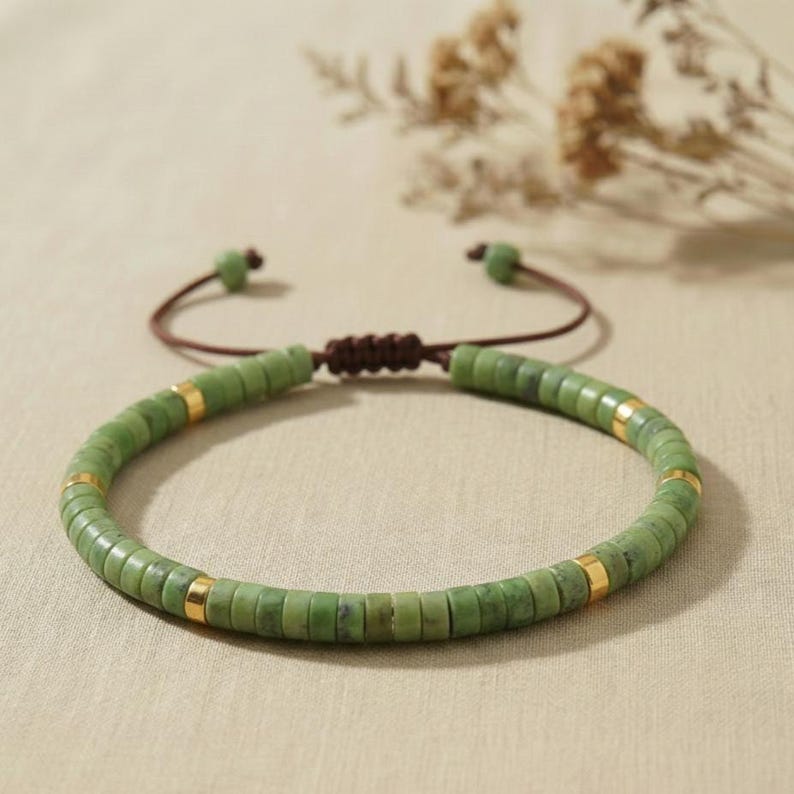 Rund drapiertes Serpentin Naturstein Armband mit 6mm Heishi Perlen vor hellem, schlichtem Hintergrund.