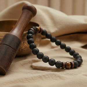 Das schwarz-braune Armband wird am Handgelenk eines Mannes getragen, kombiniert mit Freizeitkleidung.