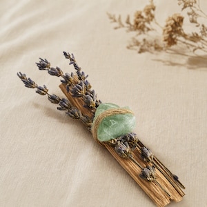 Palo Santo Räucherbündel mit getrocknetem Lavendel und grünem Aventurin auf beigem Leinenstoff