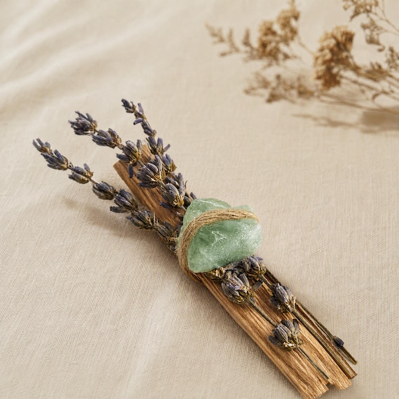 Palo Santo Räucherbündel mit getrocknetem Lavendel und grünem Aventurin auf beigem Leinenstoff