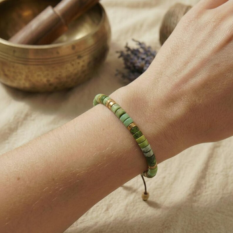 Zartes grünes Serpentin Flachperlen Armband getragen an einem Handgelenk im minimalistischen Boho Stil.