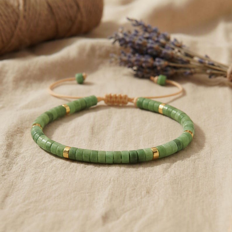 Hand hält das elastische Serpentin Armband und zeigt die geschliffenen flachen Perlenkanten und Natursteinmaserung.