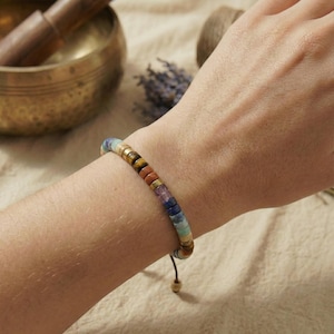 Chakra-Armband aus natürlichen Steinperlen dekorativ auf Naturleinen – bewusster Schmuck für Achtsamkeit & Balance, plastikfrei verpackt.