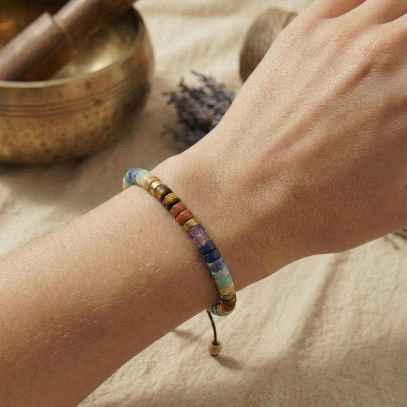 Chakra-Armband aus natürlichen Steinperlen dekorativ auf Naturleinen – bewusster Schmuck für Achtsamkeit & Balance, plastikfrei verpackt.