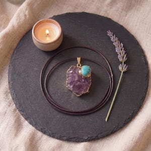 Zentrierte Draufsicht auf den Amethyst-Türkis-Talisman auf dunklem Schieferuntersetzer mit Kerzenschein und Lavendelzweig.