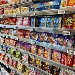 Peut inclure: &Eacute;tag&egrave;res de supermarch&eacute; remplies de collations emball&eacute;es, notamment des biscuits, des crackers et des gaufrettes. Des marques comme Ritz, Oreo et Salty sont visibles. Une grande vari&eacute;t&eacute; de produits est pr&eacute;sent&eacute;e.