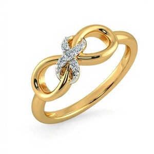Op de afbeelding: Een goudkleurige ring met een oneindigheidssymboolontwerp. De ring heeft een kleine cluster van heldere edelstenen in het midden van het oneindigheidssymbool. De ring staat tegen een witte achtergrond.